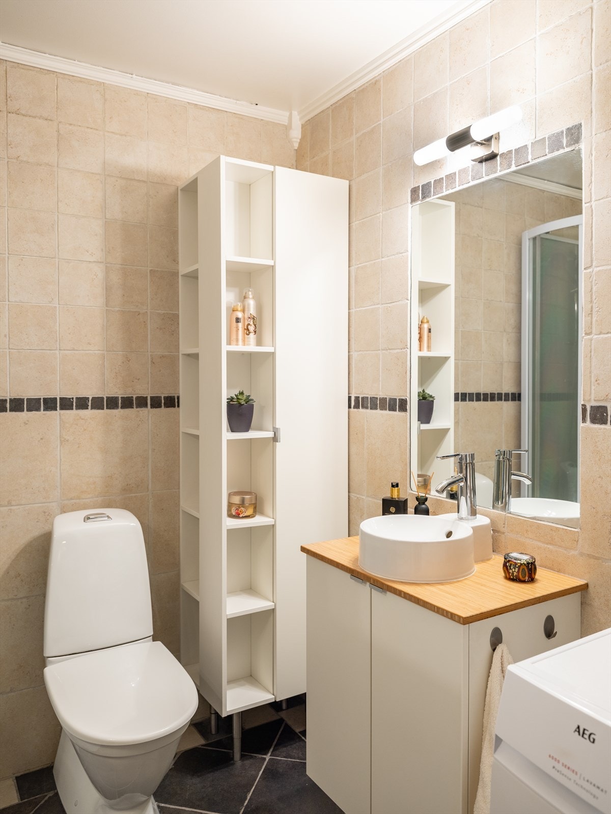 Badet er utstyrt med dusjkabinett, mekanisk avtrekk, opplegg for vaskemaskin, servantskap og wc. Galleribilde