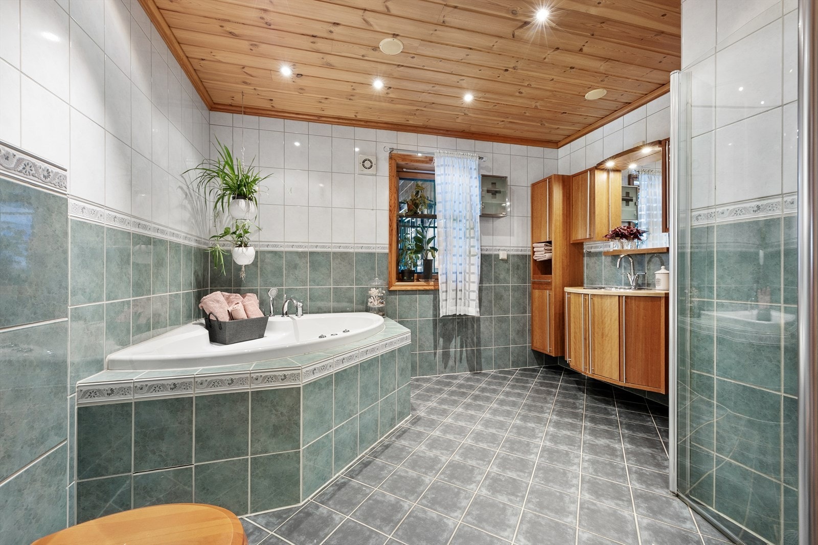 Romslig bad i første etasje med både dusjhjørne med innfellbare dører og badekar. Galleribilde