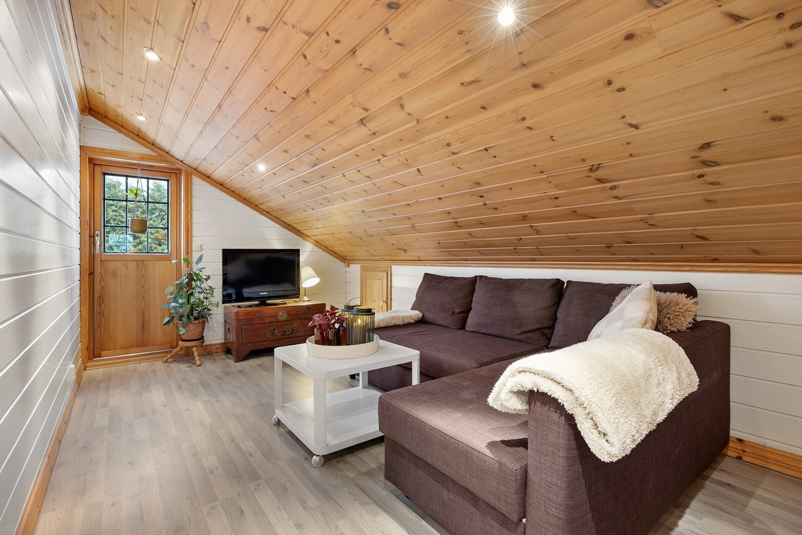 Loftstuen har skråtak, noe som gir en lun og hyggelig atmosfære. Galleribilde