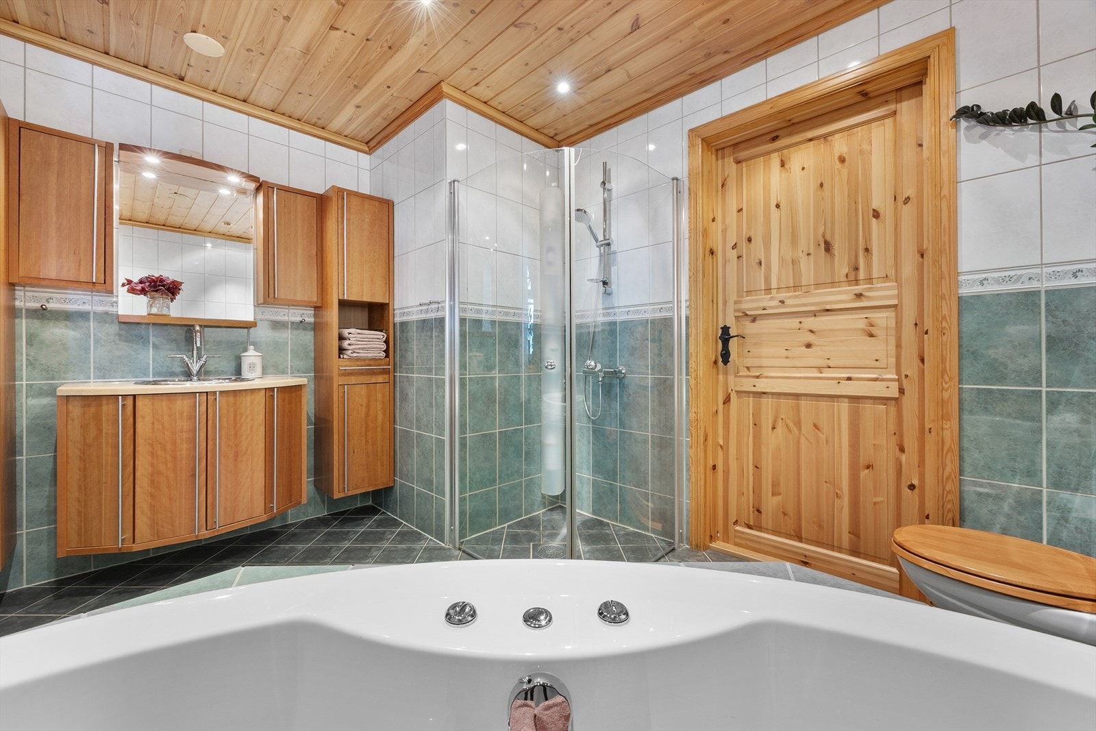 Baderomsinnredning med profilerte fronter, servant og speil med belysning. Galleribilde