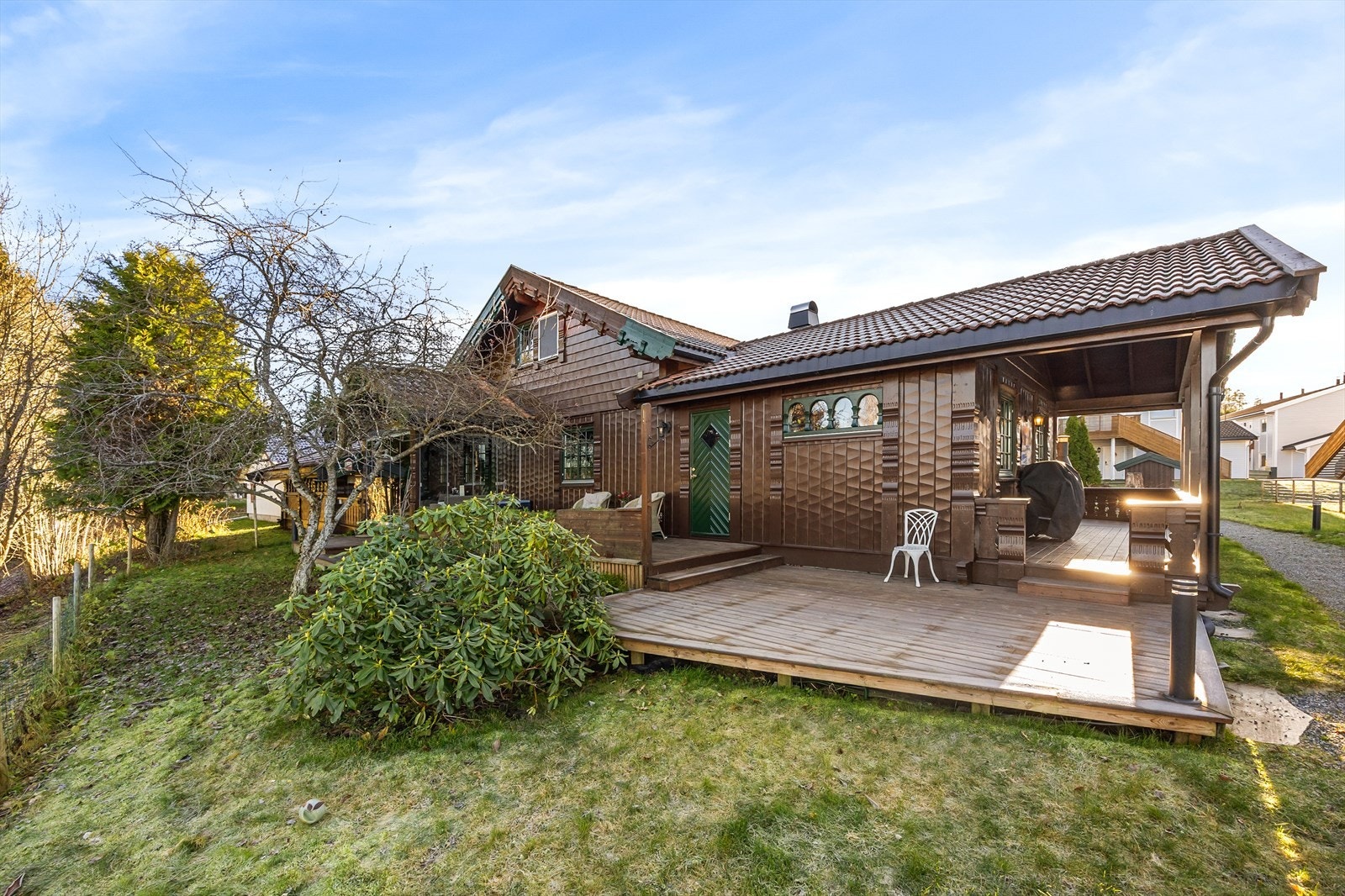 Uteområdet er pent opparbeidet med plen, busker og trær. Galleribilde