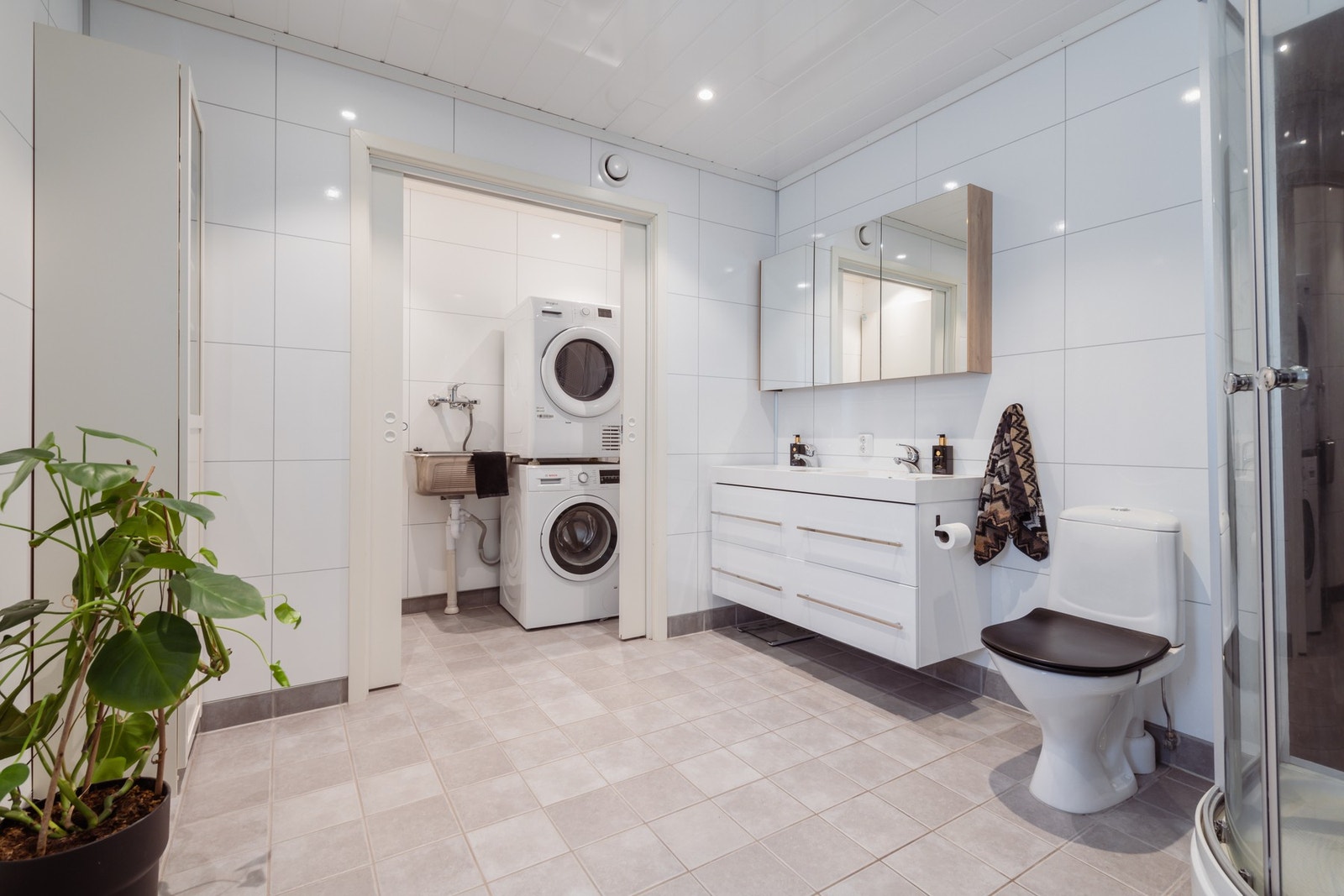 På badet er det egen vaskeromsavdeling, praktisk skjult bak skyvedører Galleribilde