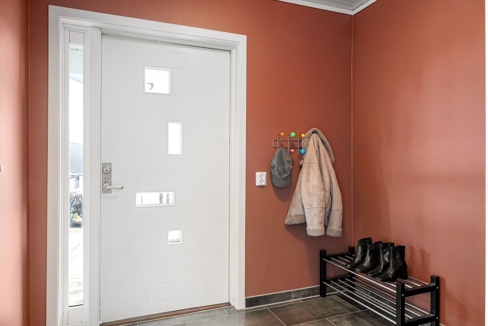 Man blir møtt av en romslig entre med fliser på gulv og god plass til å henge fra seg. Galleribilde