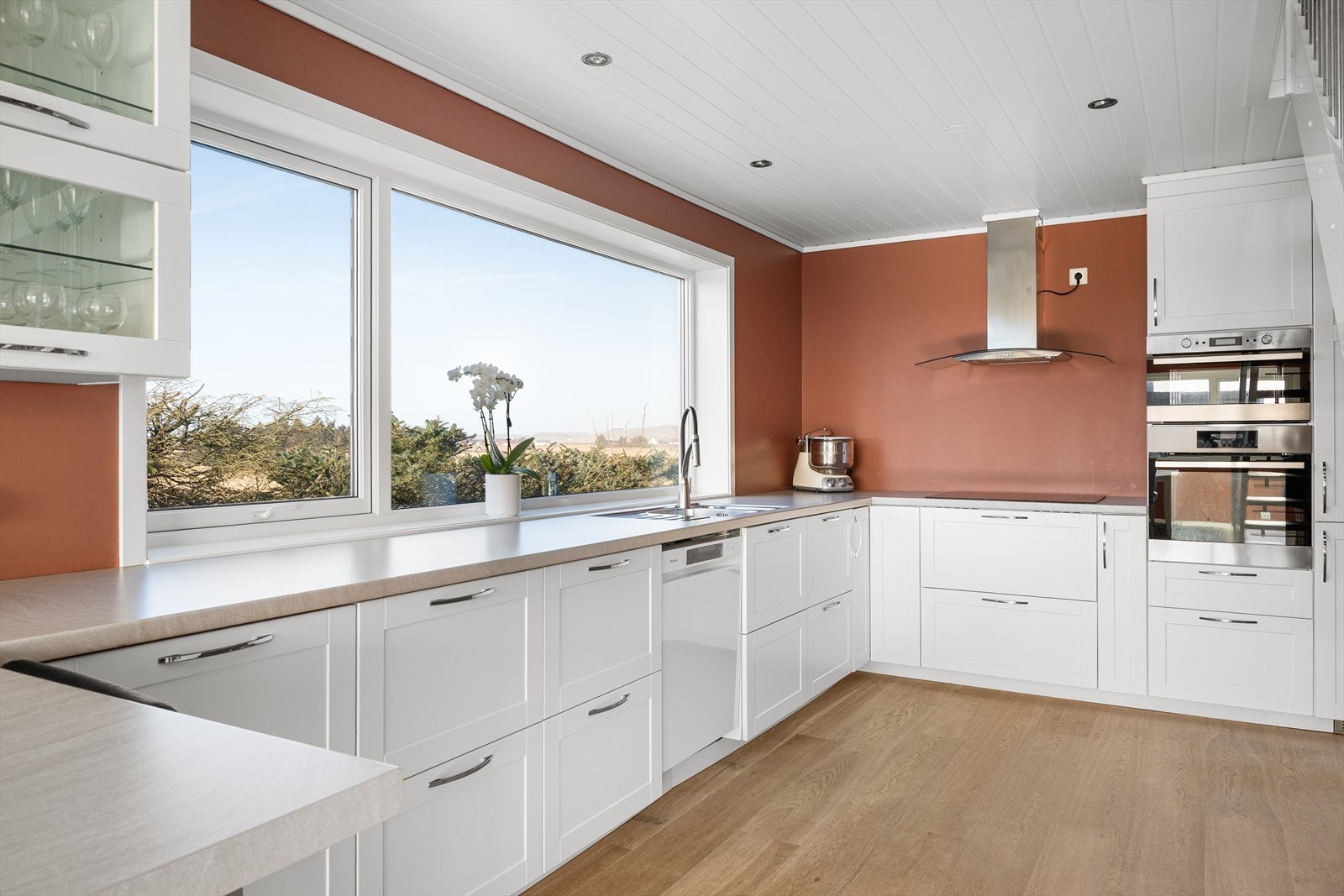 Kjøkkenet har god størrelse og er innredet med hvite, profilerte fronter, integrerte hvitevarer og benkeplate i laminat. Galleribilde