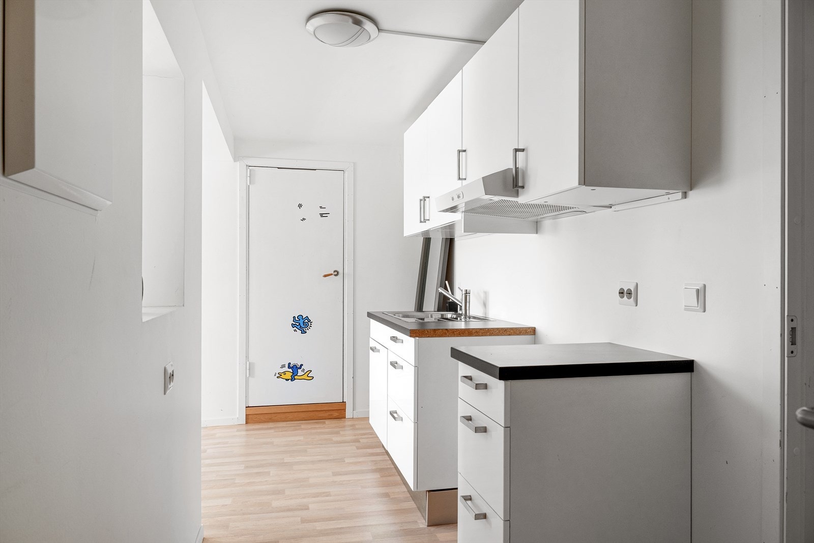 Kjøkkenet har klassiske hvite fronter og rommet har plass til både spisebord og sofagruppe. Galleribilde