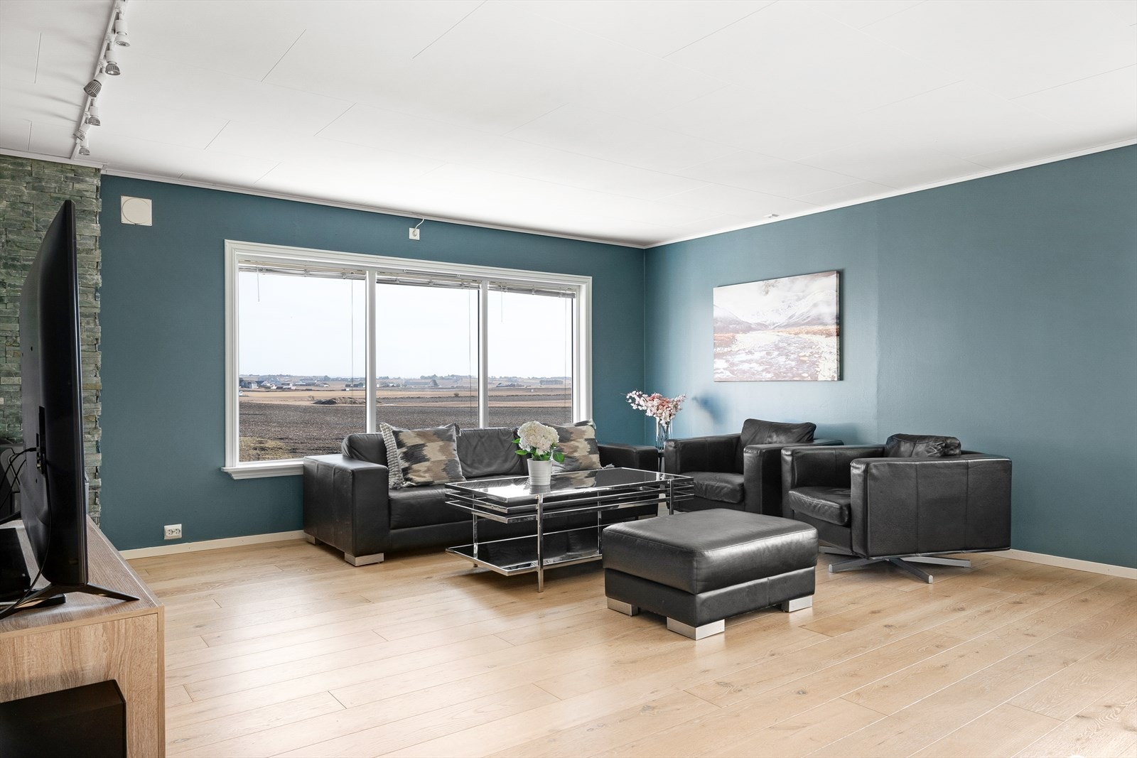 Stuen er romslig og innbydende med store vindusflater som slipper inn rikelig naturlig lys og skaper en luftig og behagelig atmosfære. Galleribilde