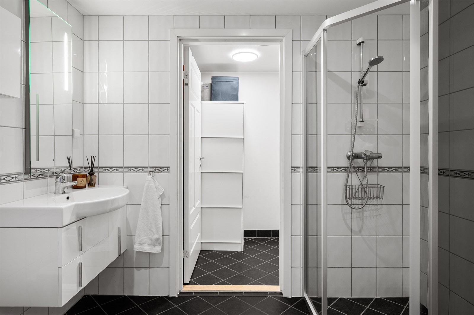 - Badet er innredet med heldekkende servant, speil med belysning, vegghengt toalett, og buet hjørnedusj - Galleribilde