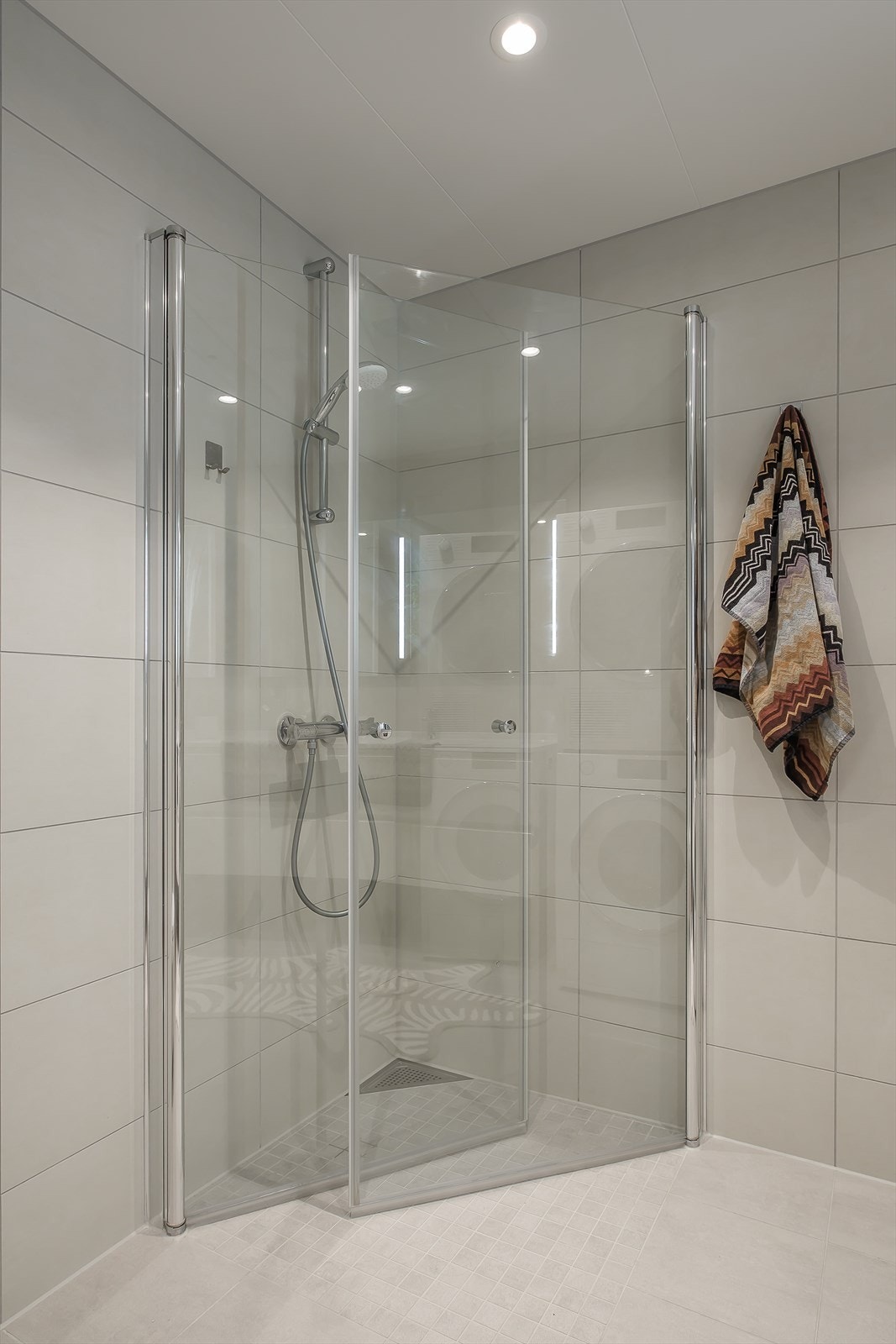 Dusjhjørnet har innfellbare dusjdører som bidrar til en praktisk og plassbesparende løsning. Galleribilde