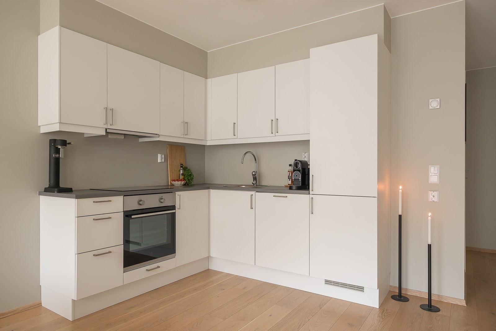 Lyst og moderne kjøkken med integrerte hvitevarer og rikelig med skapplass. Galleribilde