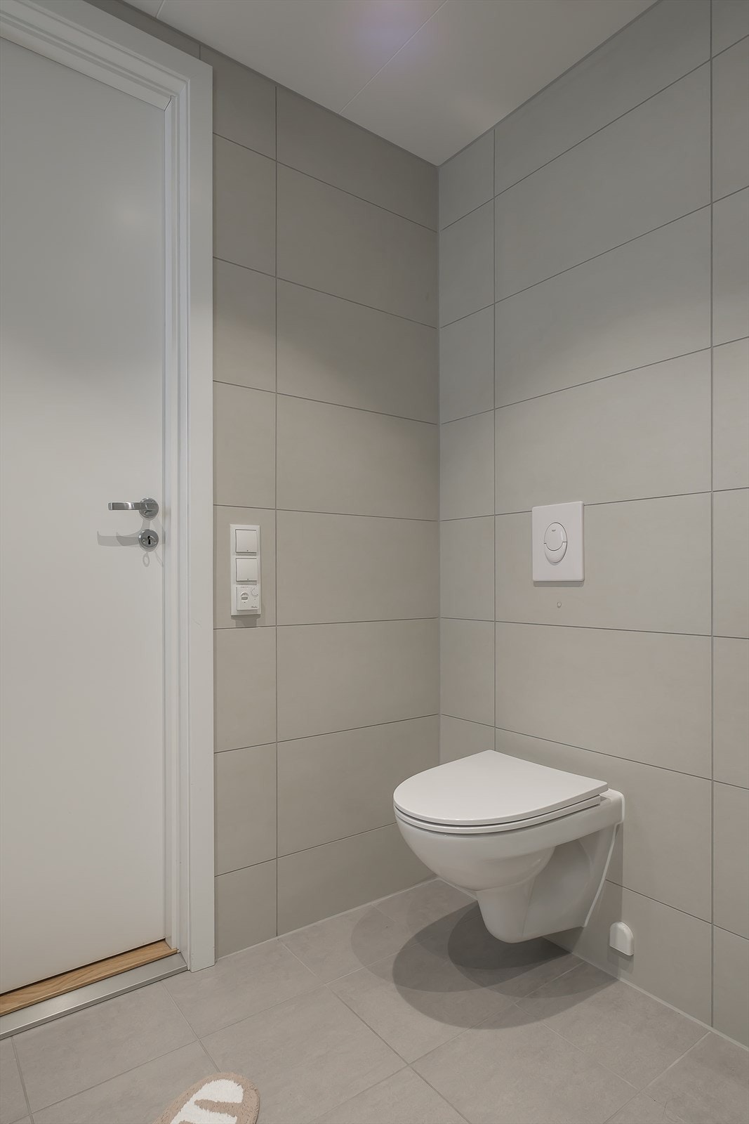 Flislagt bad med komfortabel gulvvarme og downlights i taket som gir godt lys. Store fliser skaper et moderne og stilrent helhetsinntrykk. Galleribilde