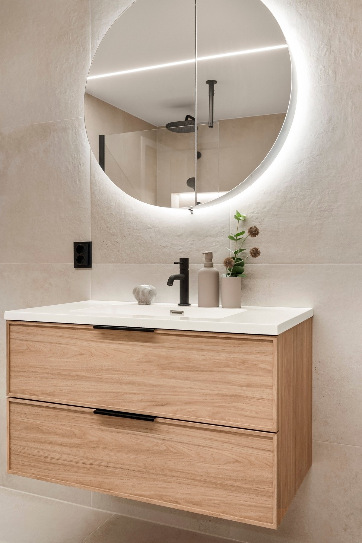 Badet har vegghengt servantinnredning med skuffer og ovenpåliggende servant, samt overskap med speilfronter og integrert lys på vegg over servant. Galleribilde