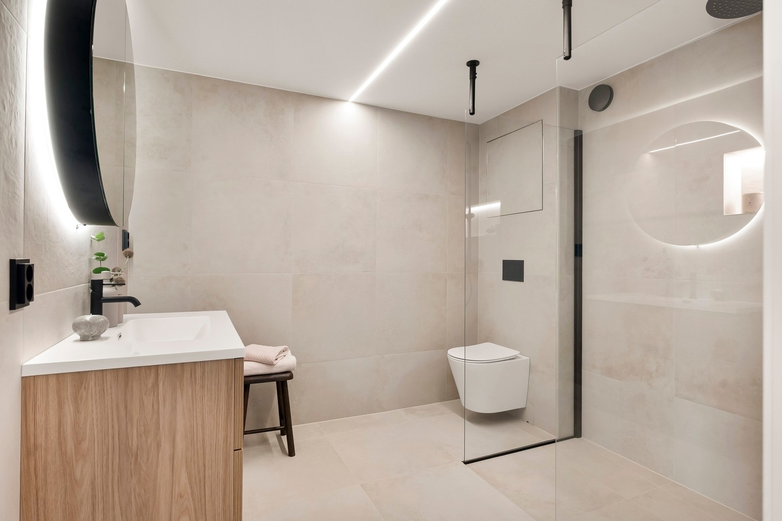 Leiligheten har et lekkert flislagt bad fra 2026 med opplegg for vaskemaskin, behagelig gulvvarme og himling med integrert lyslist. Galleribilde