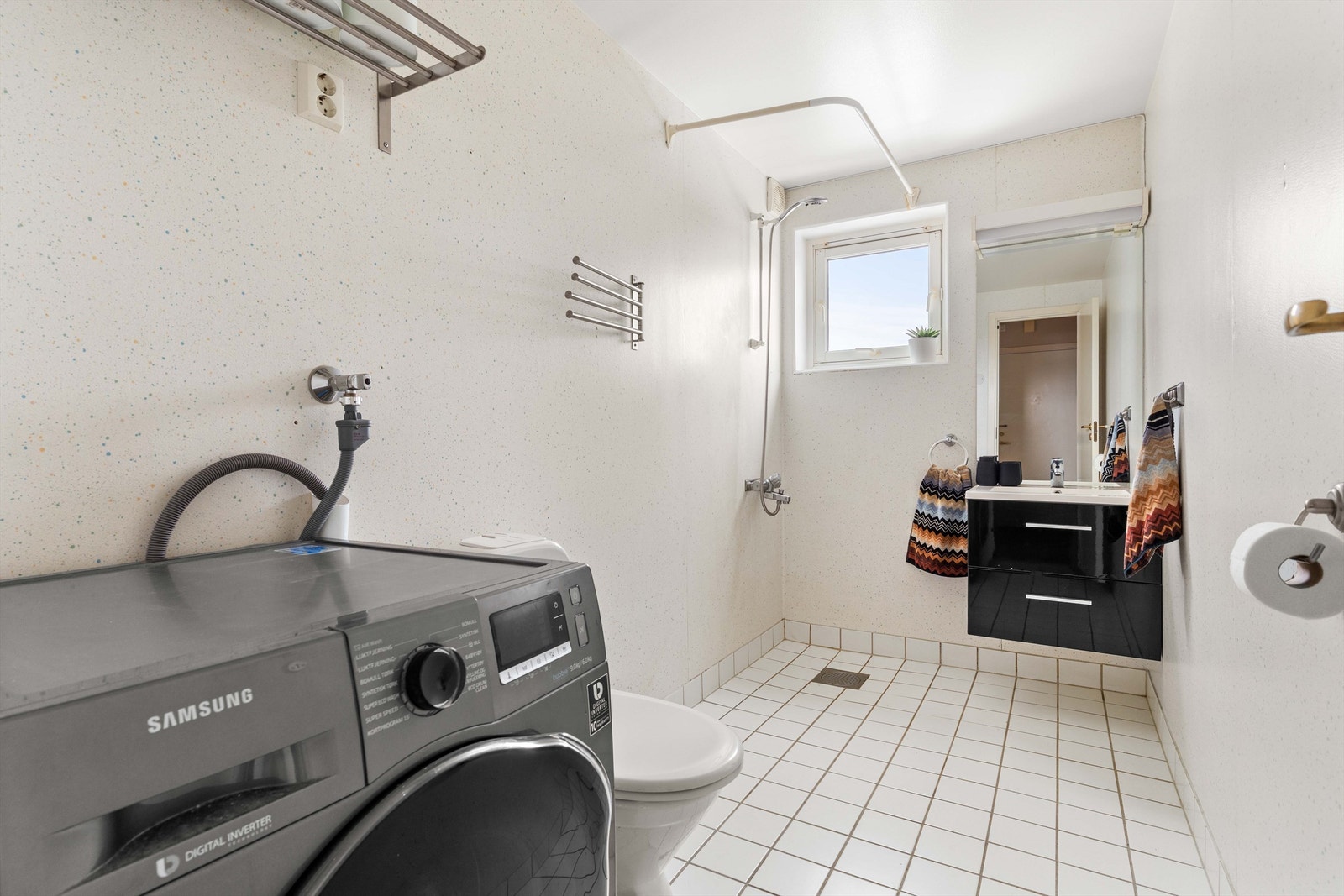 Her er det også gulvmontert toalett og praktisk opplegg for vaskemaskin. Galleribilde