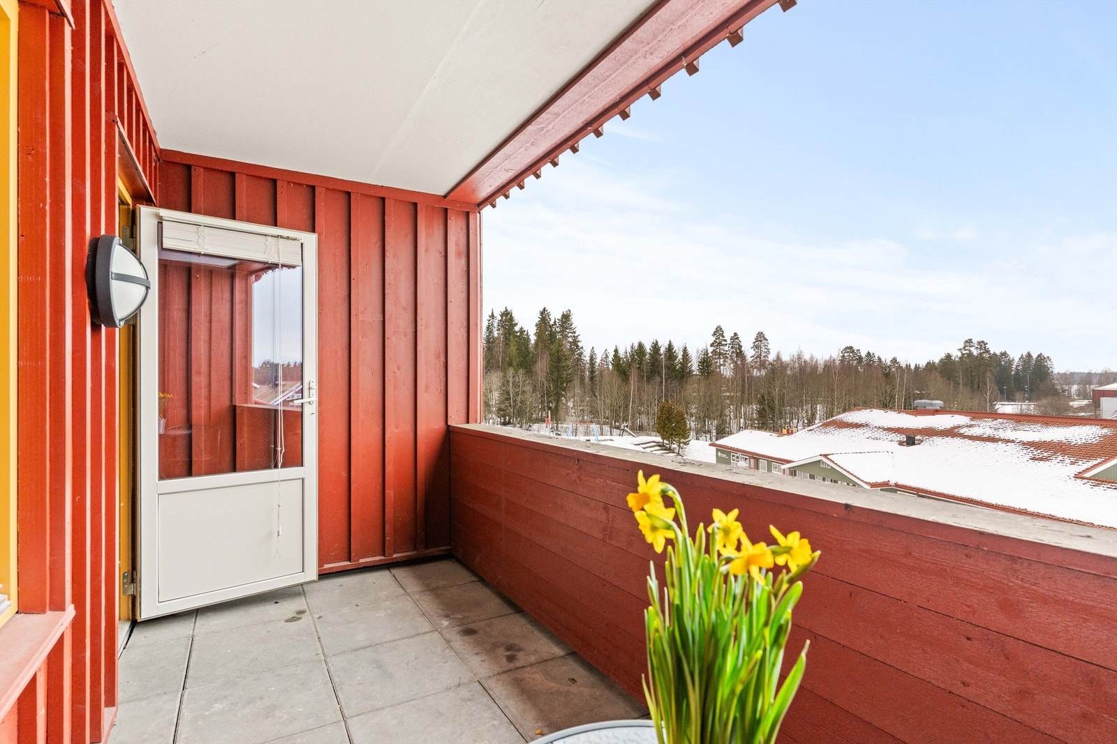 Balkongen har betongheller på gulvet, rekkverk av tre, samt utelys og stikkontakt. Galleribilde