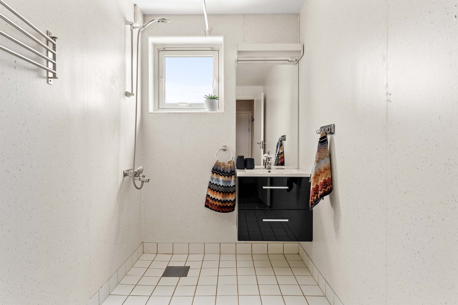 Badet er utstyrt med dusjnisje, servant med underskap og har elektrisk gulvvarme. Galleribilde