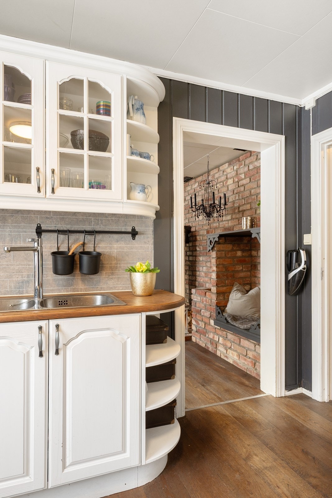 Innredningen har en kombinasjon av åpne hyller og vitrineskap for oppbevaring. Galleribilde