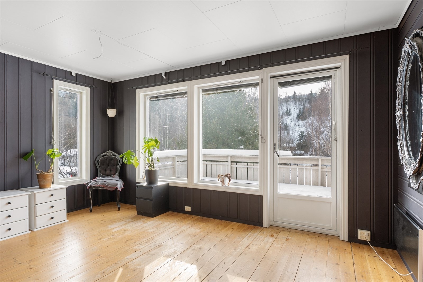 Stua i 2. etg har panelte vegger og gulv av heltre, og det er utgang til veranda. Galleribilde