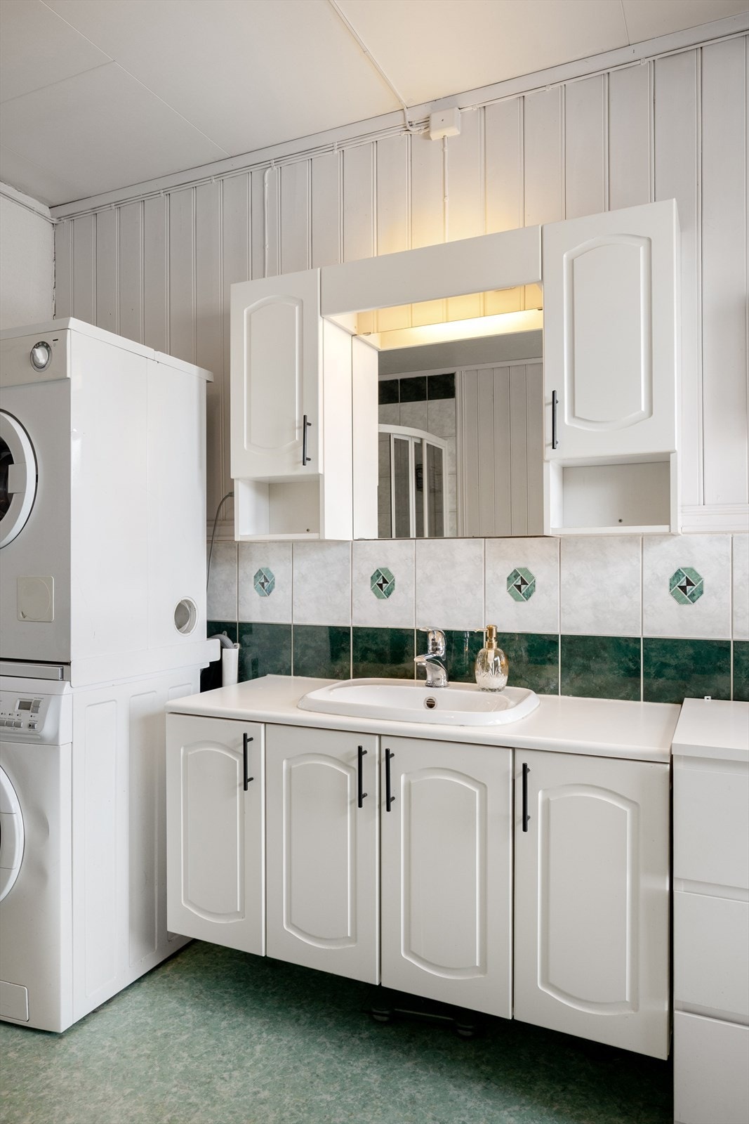 Baderomsinnredningen gir god oppbevaringsplass i skap og overskap med speil. Galleribilde