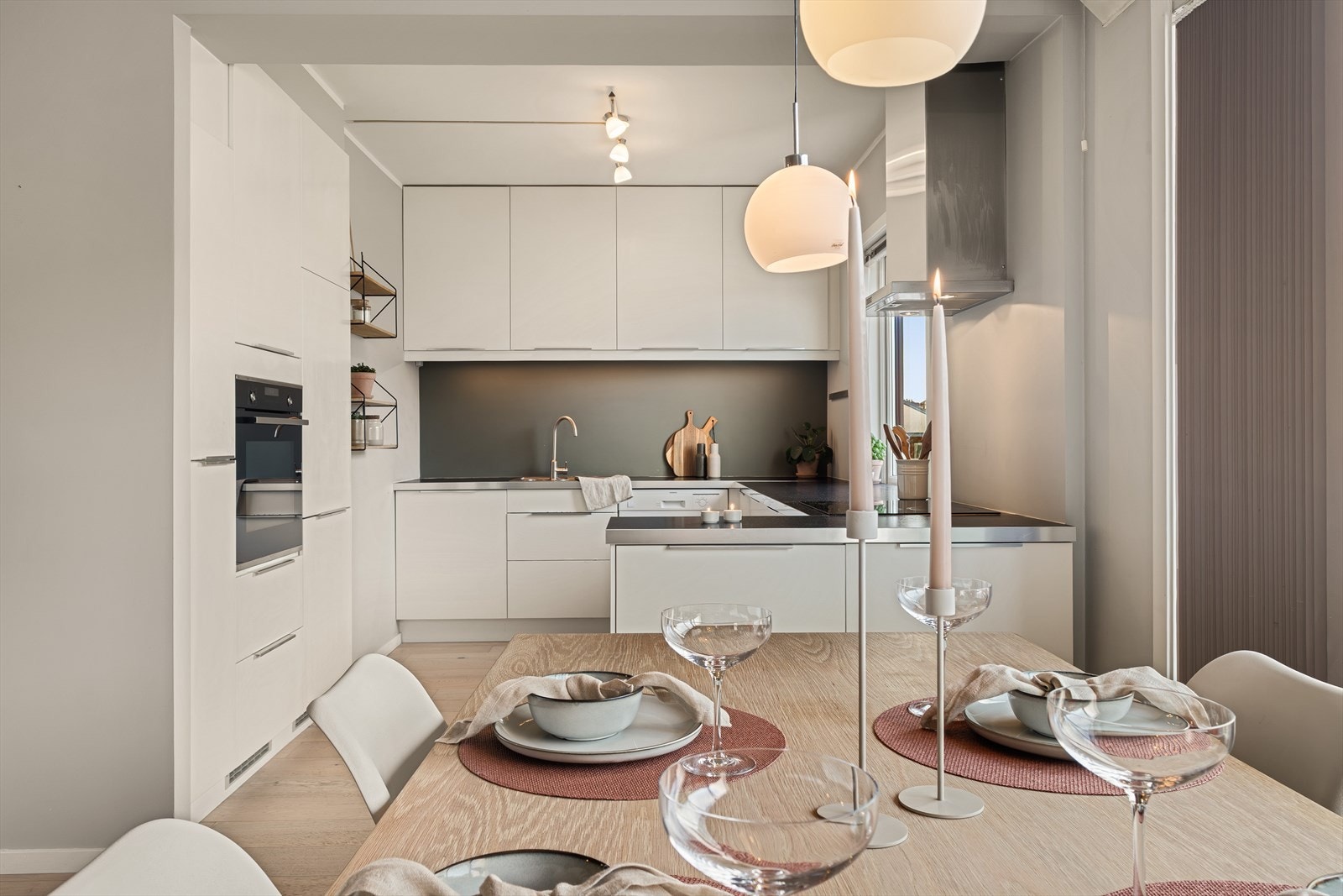 Pent kjøkken fra IKEA med hvite, slette fronter og benkeplate av laminat. Galleribilde