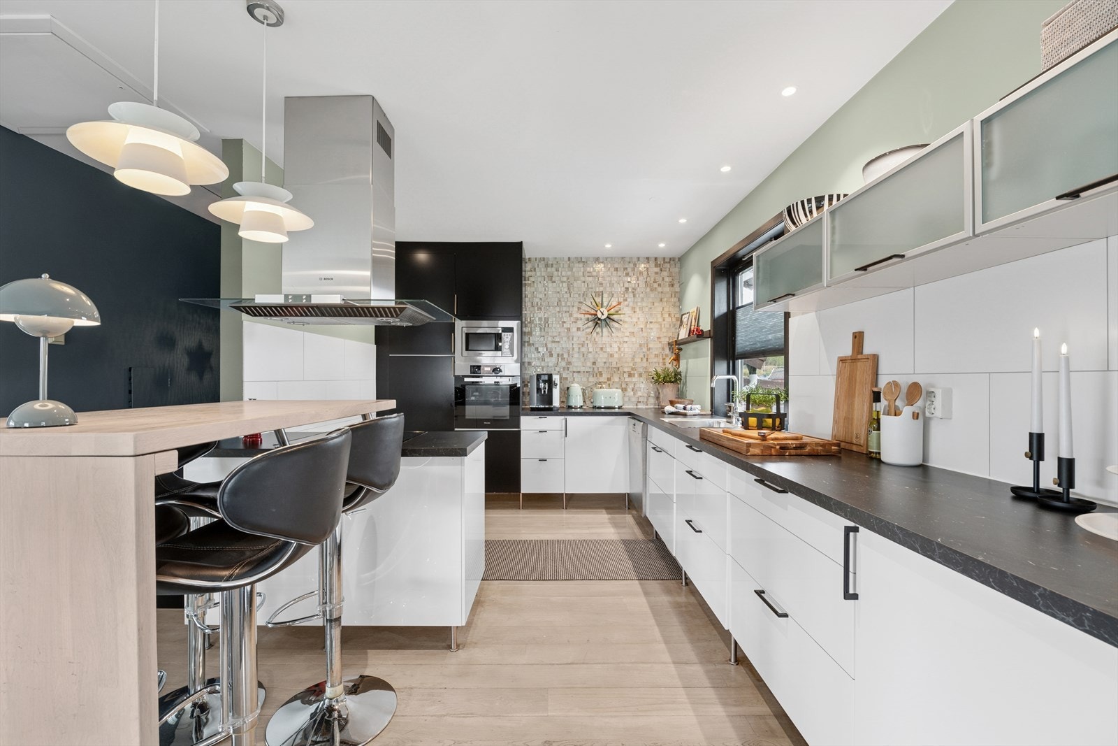 Kjøkken med fliser på vegg over benkeskap samt laminat benkeplate med nedfelt kum i rustfritt stål. Kjøkkenventilator med avtrekk gjennom yttertak. Galleribilde