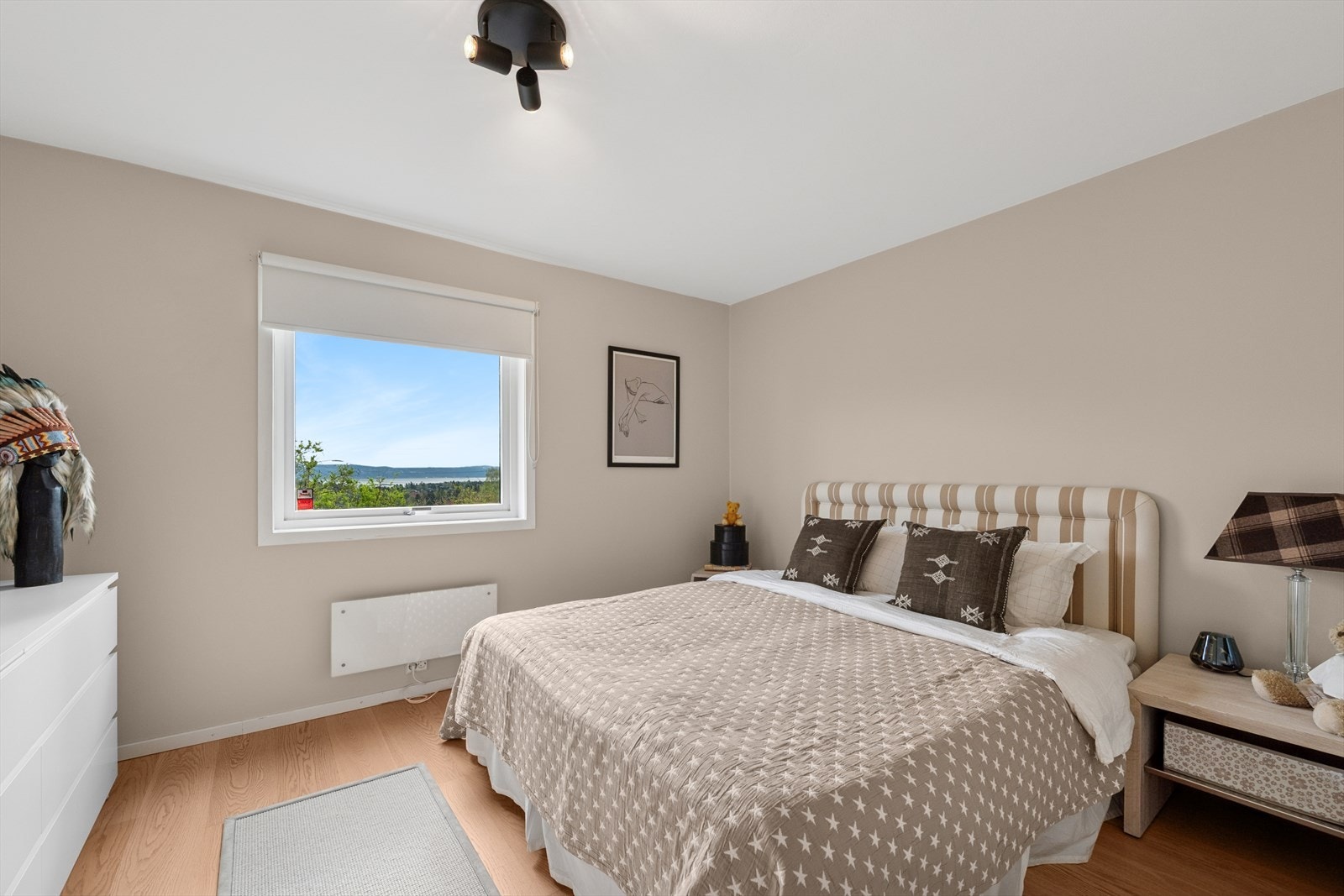 Lyst og innbydende soverom med plass til dobbeltseng og nattbord. Galleribilde