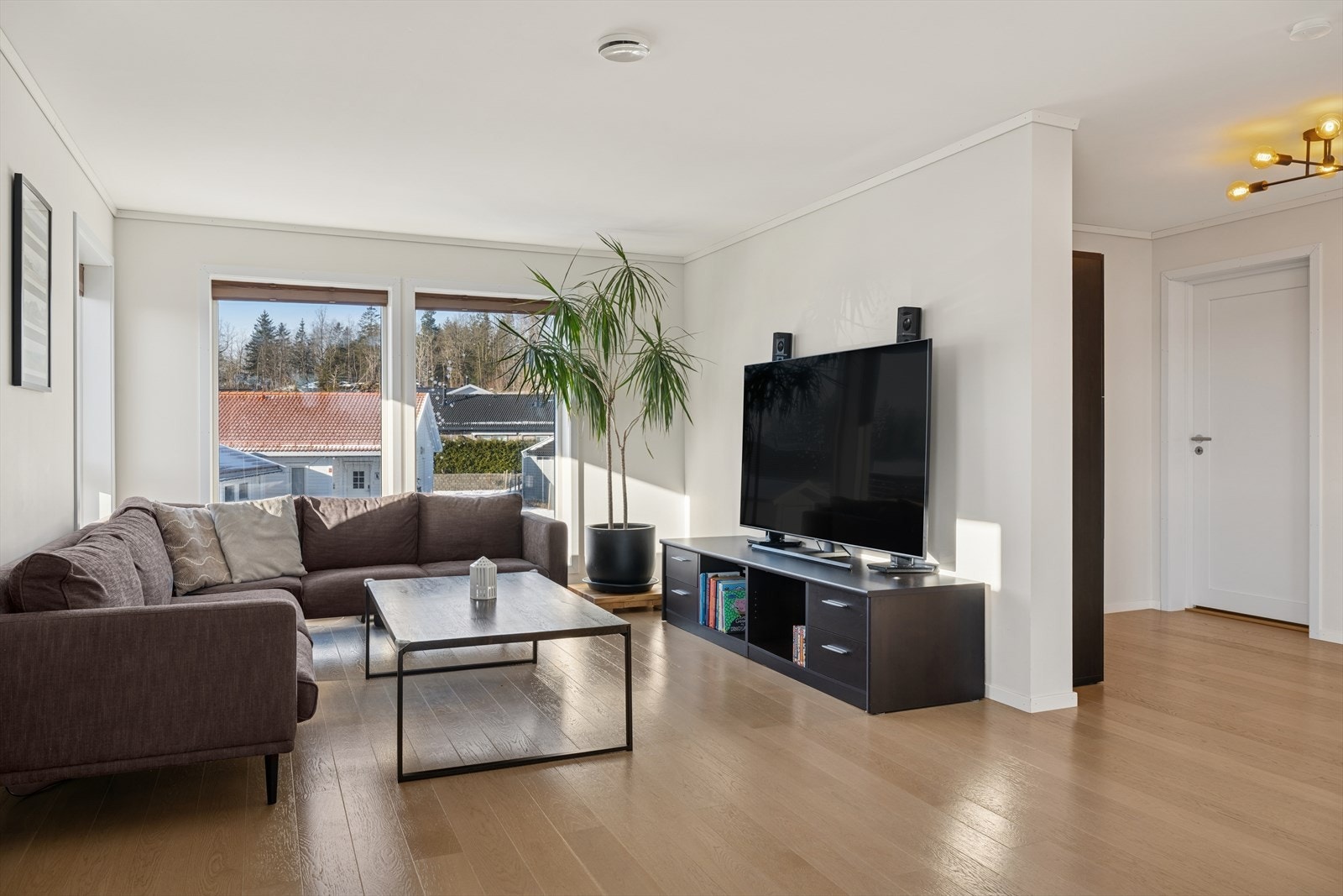 Plasseringen av sofagruppen ved vinduene skaper en koselig, lysfylt sone perfekt for avslapping. Galleribilde