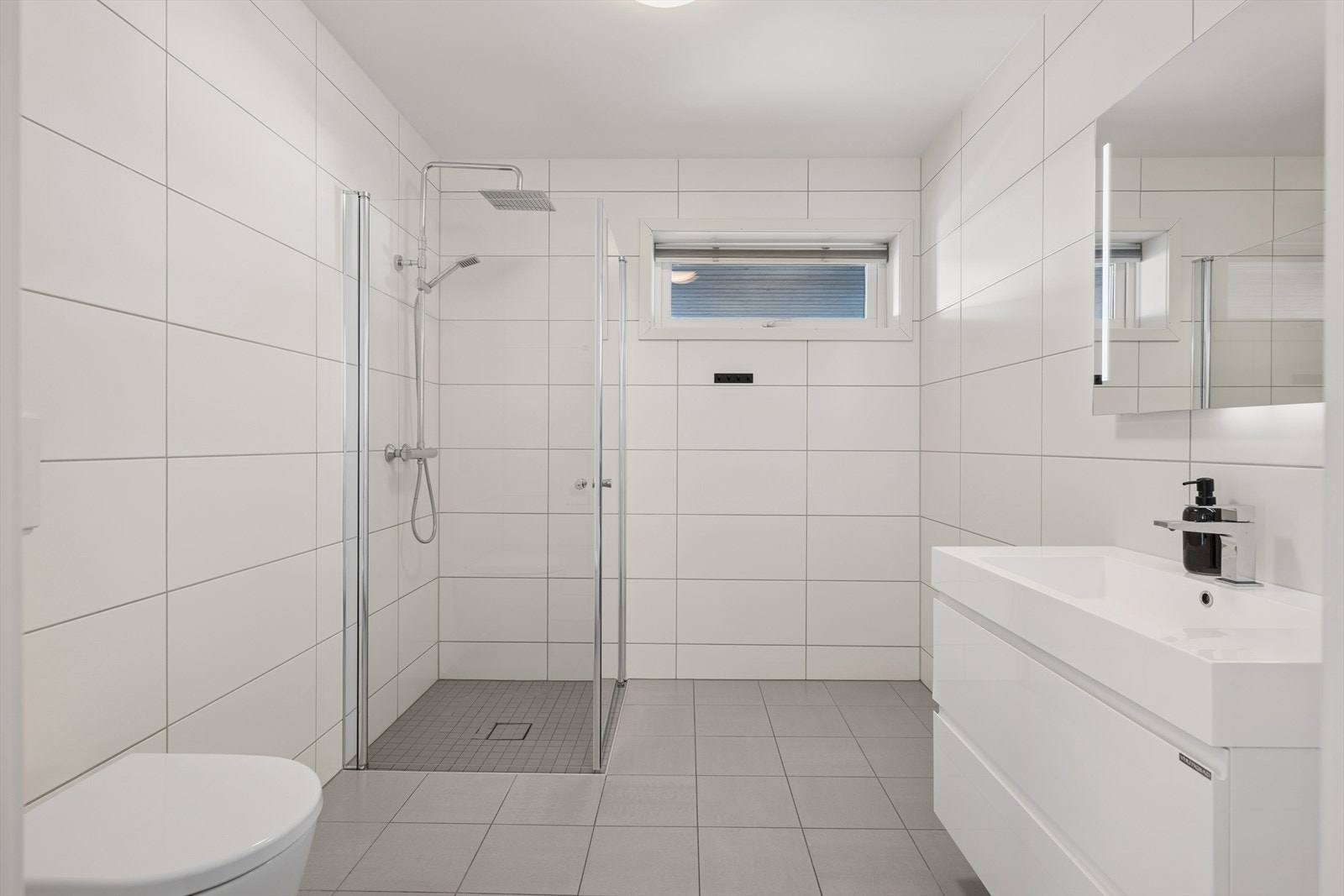 Baderommet i første etasje er også helfliset og oppvarmet med vannbåren gulvvarme, noe som gir både komfort og et energieffektivt inneklima. Galleribilde