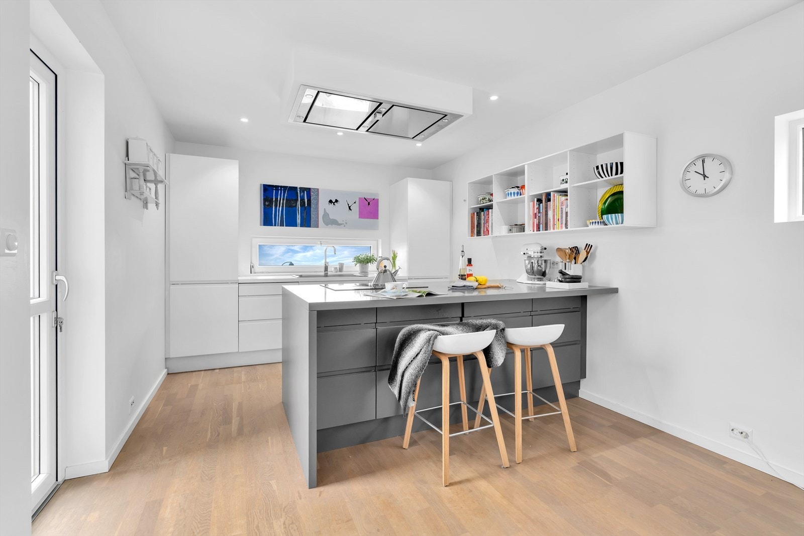 En romslig kjøkkenøy med barløsning fungerer som et naturlig skille mellom kjøkken og spiseplass Galleribilde