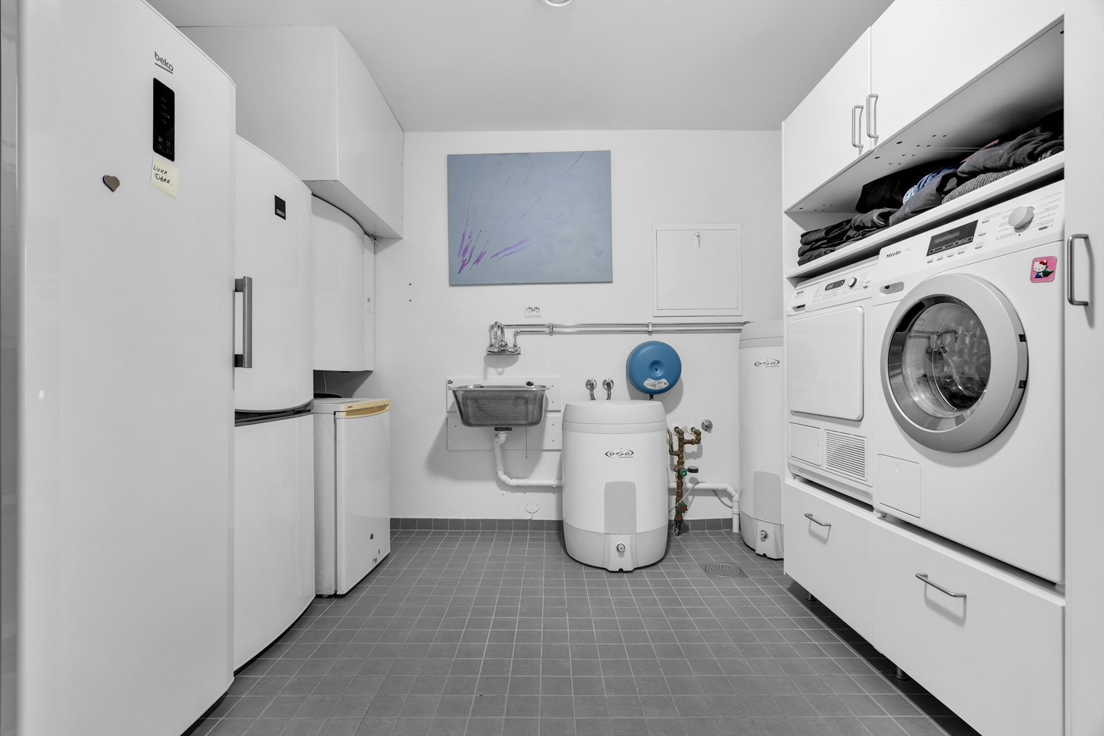 Her finner du en utslagsvask og opplegg for vaskemaskin, samt godt med oppbevaringsplass. Galleribilde