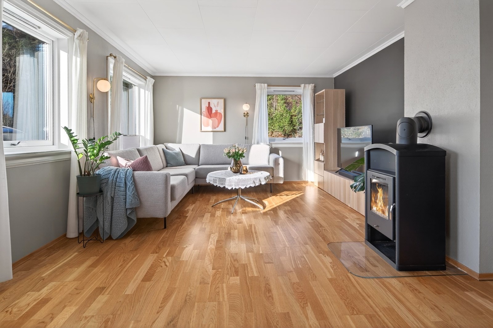 Leiligheten har en lys og luftig stue med store vinduer som sørger for godt med naturlig lys Galleribilde