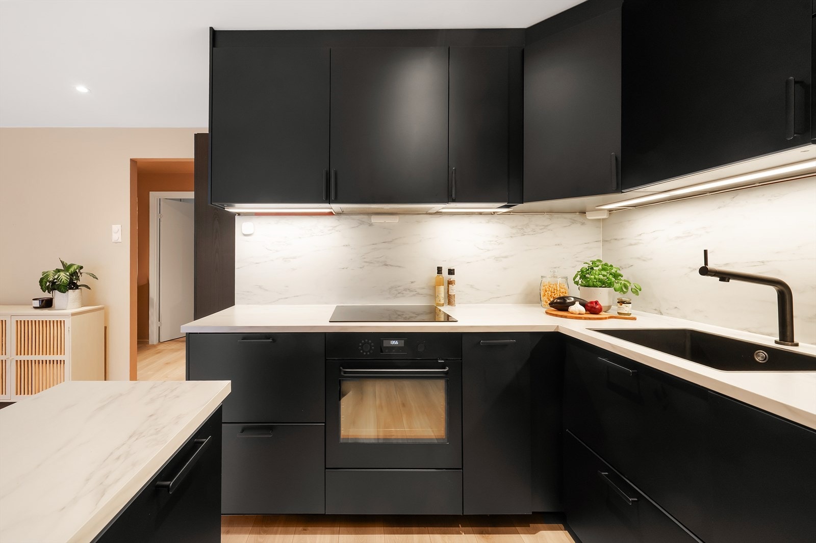 Innredningen består av mørke, glatte fronter som står i elegant kontrast til den lyse laminatbenkeplaten. Videre er det interegrert platetopp, stekeovn, mikrobølgeovn, oppvaskmaskin og kjøl/frys. Galleribilde