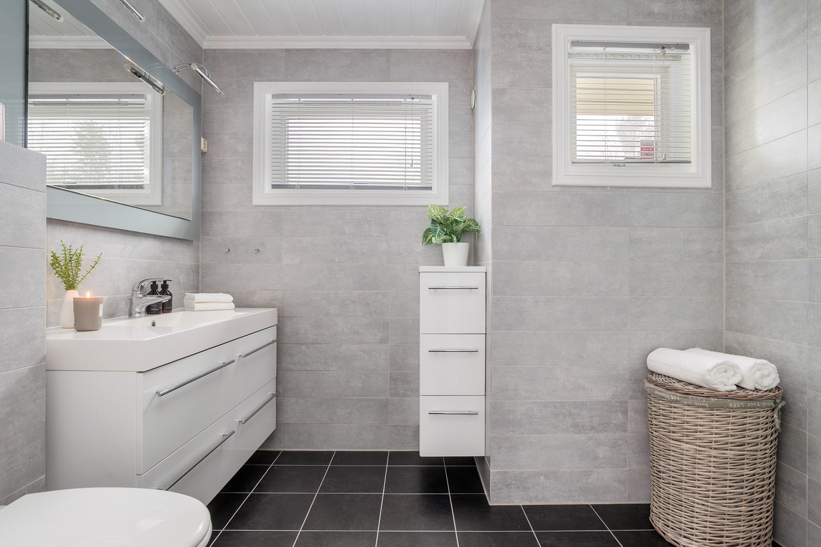 Badet i 1. etasje er fra 2008. Rommet er innredet med servantskap med nedfelt servant, speil med belysning over og vegghengt klosett med innebygd sisterne. Galleribilde