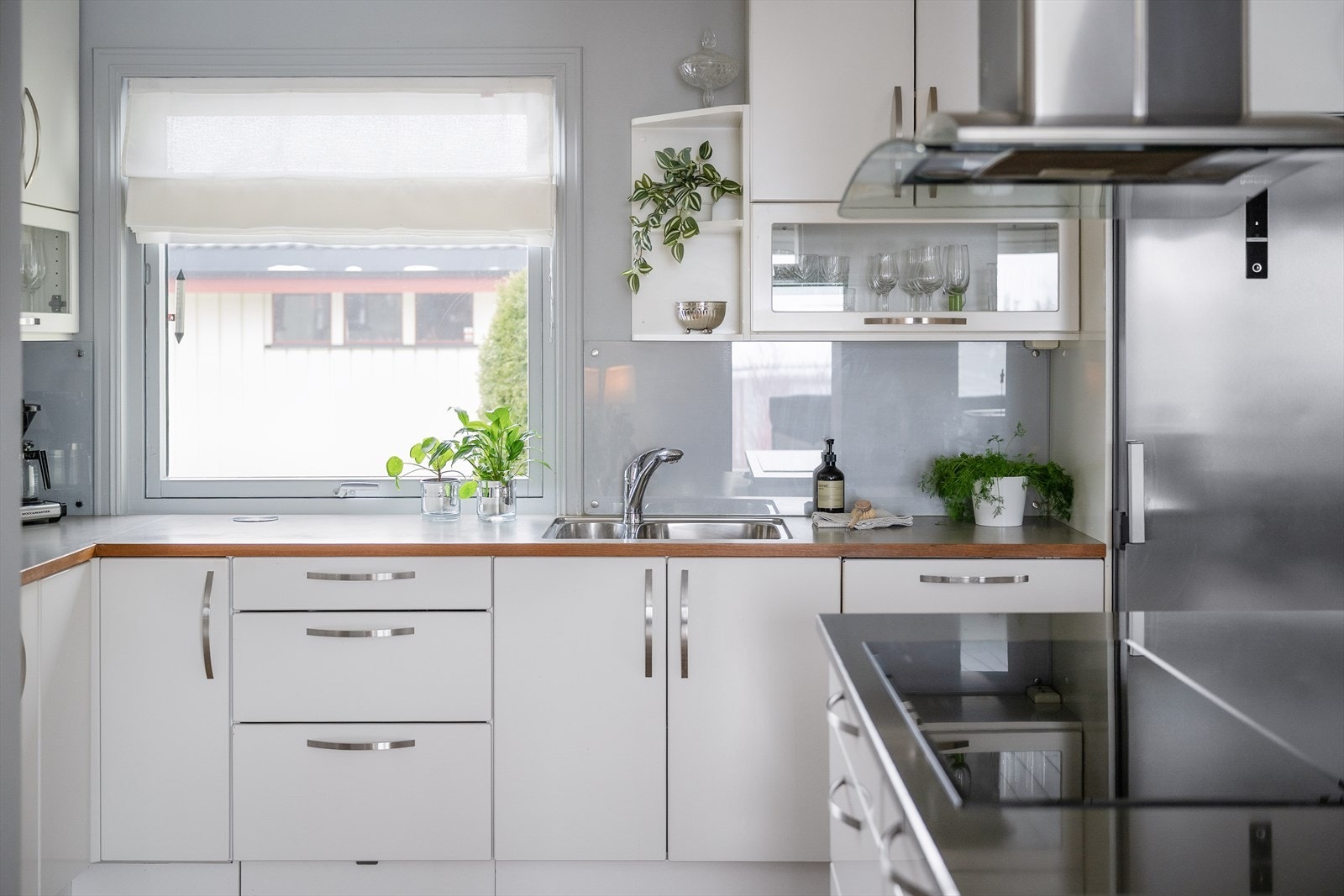 Det er montert belysning under overskapene, og veggen mellom benkeplate og overskap er utført med glassplater. Galleribilde