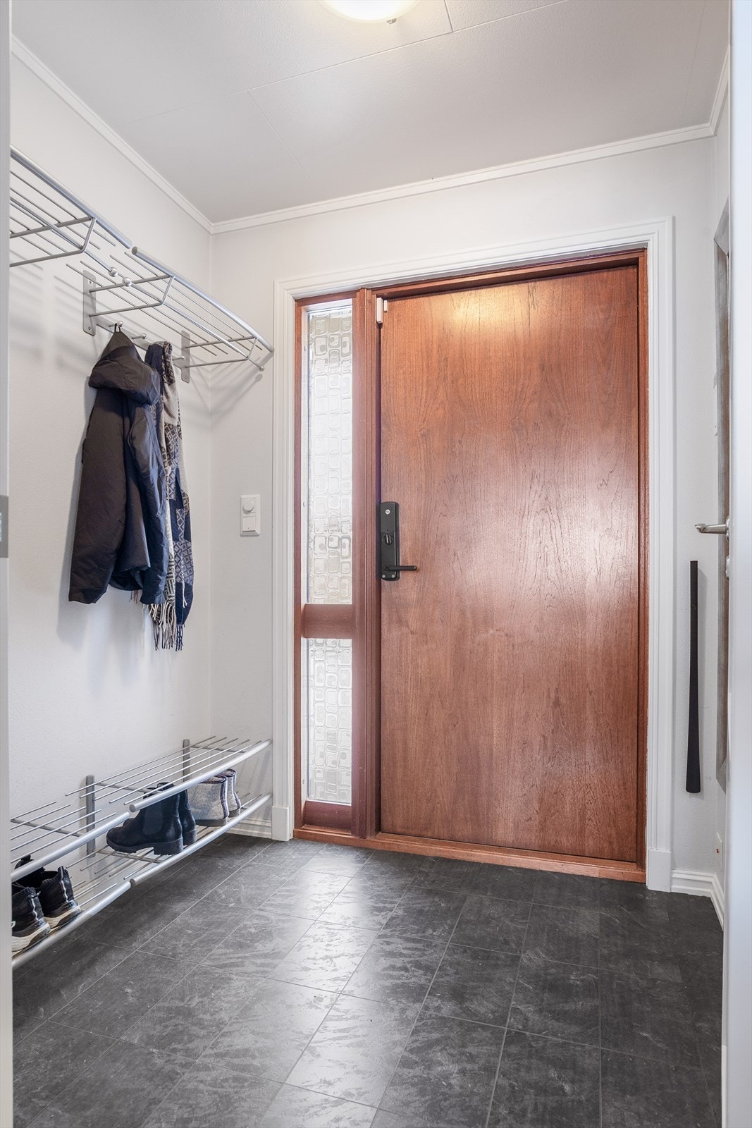 Entréen er praktisk utformet med god plass til oppbevaring av yttertøy og sko langs veggen. Galleribilde