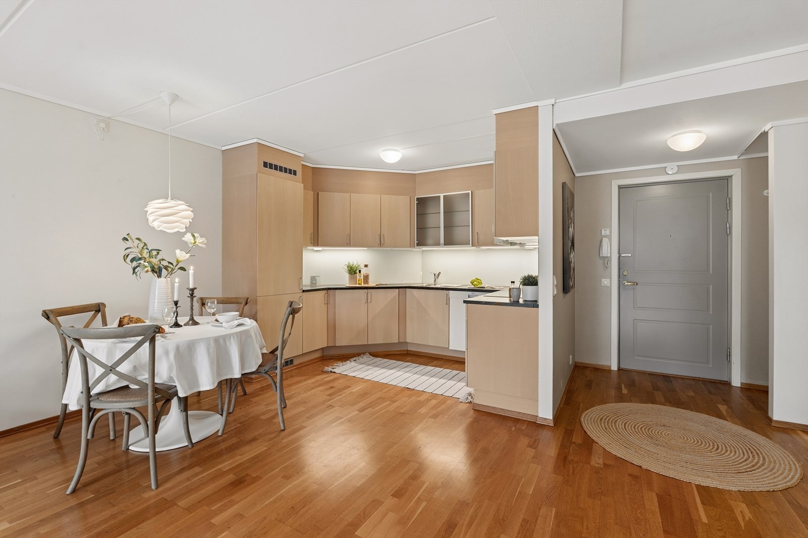 Innredningen består av glatte fronter, et overskap med glass, stålhåndtak og en laminert benkeplate som gir et rent og tidløst uttrykk Galleribilde