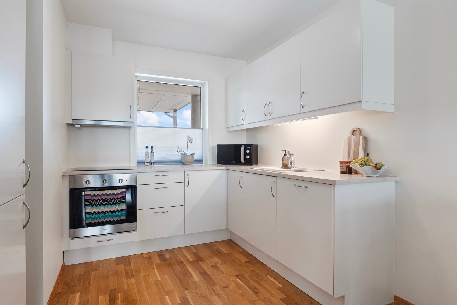 Innbydende kjøkken med integrerte hvitevarer som medfølger i handelen. Galleribilde