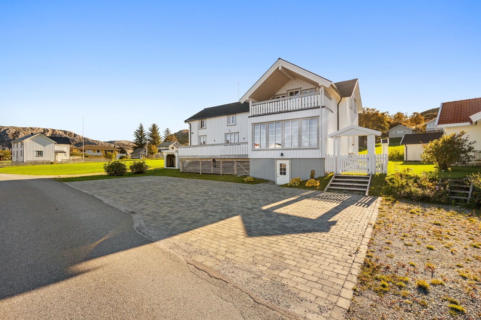 Steinbelagt oppstillingsplass for bil. Det er montert elbillader. Galleribilde