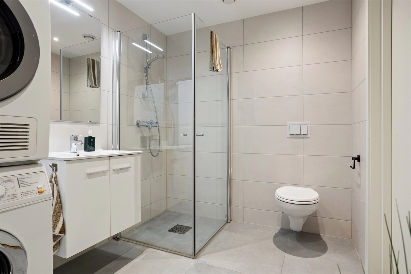 Pent og lyst bad med fliser på gulv og vegger. Galleribilde