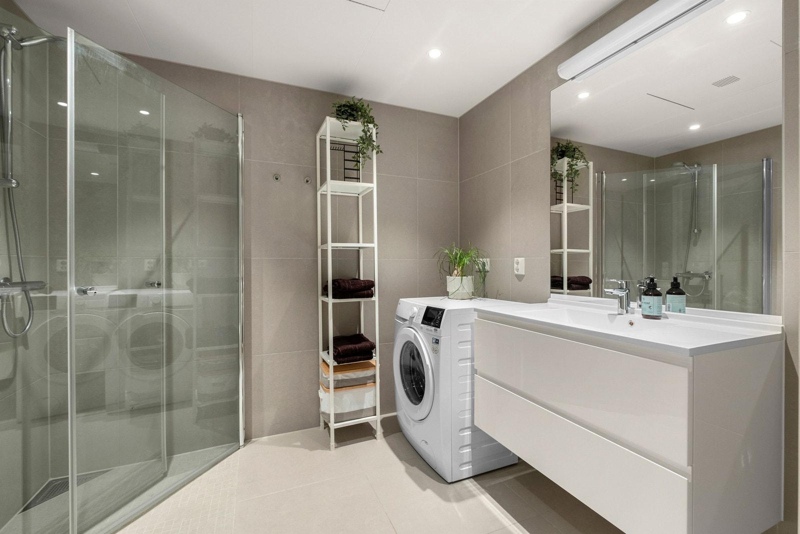 Lekkert bad med store fliser og spotter i taket. Opplegg for vaskemaskin Galleribilde