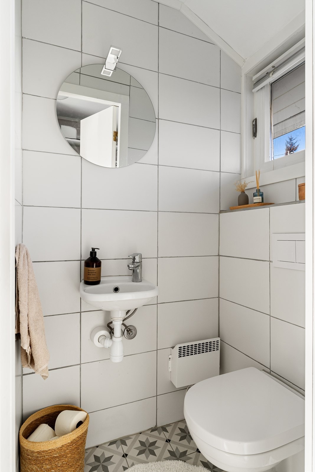 Flislagt gjestetoalett med vegghengt toalett og vask Galleribilde