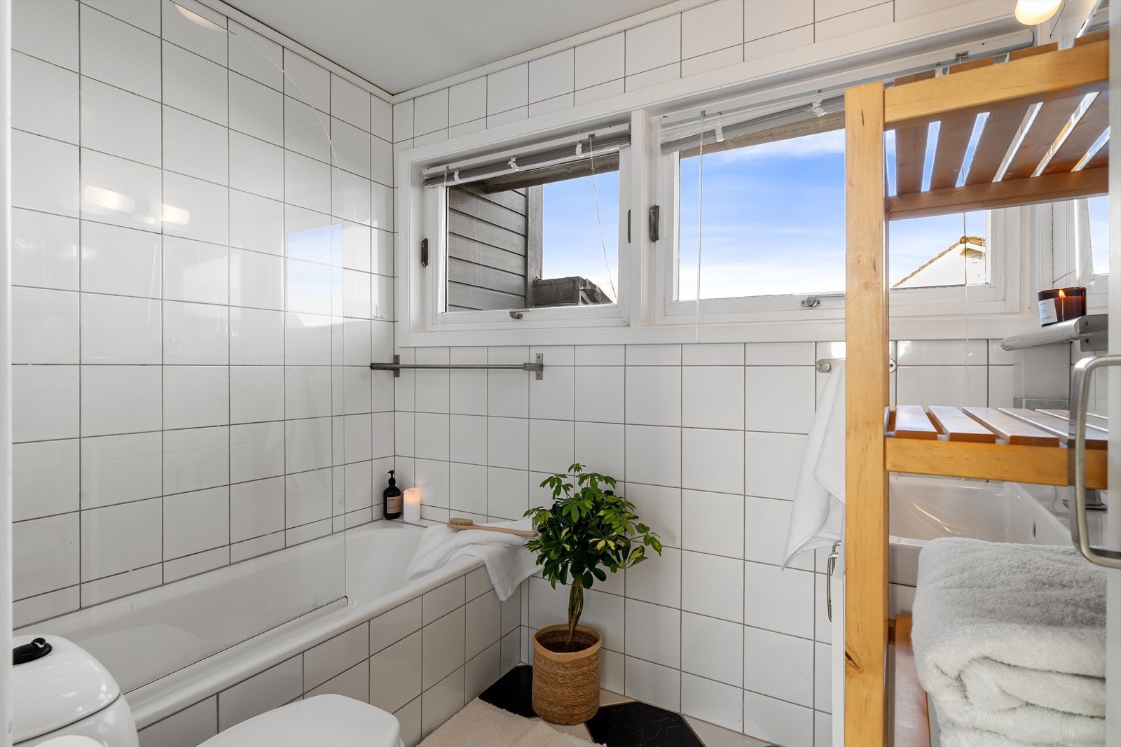 Flislagt bad med gulvvarme, badekar, toalett og vask Galleribilde