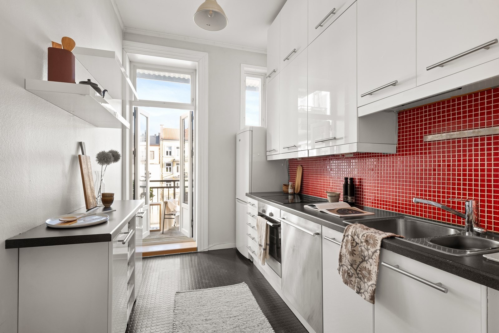 Kjøkkeninnredning med glatte fronter, laminat benkeplate med nedfelt kum i rustfritt stål. Det er godt med skapplass. Galleribilde