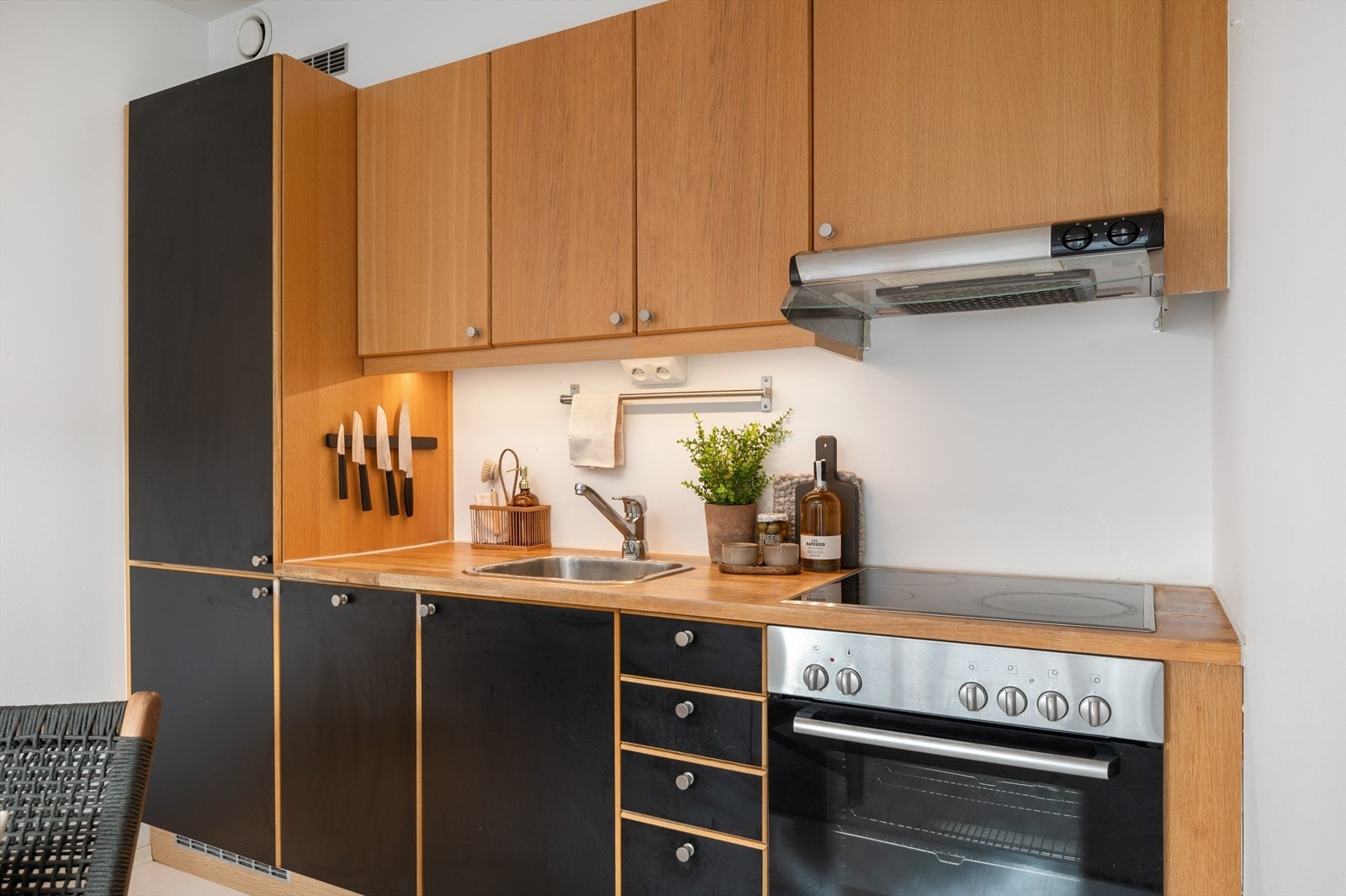 Flott kjøkken med integrerte hvitevarer som platetopp, stekeovn og kjøl- og fryseskap. Galleribilde