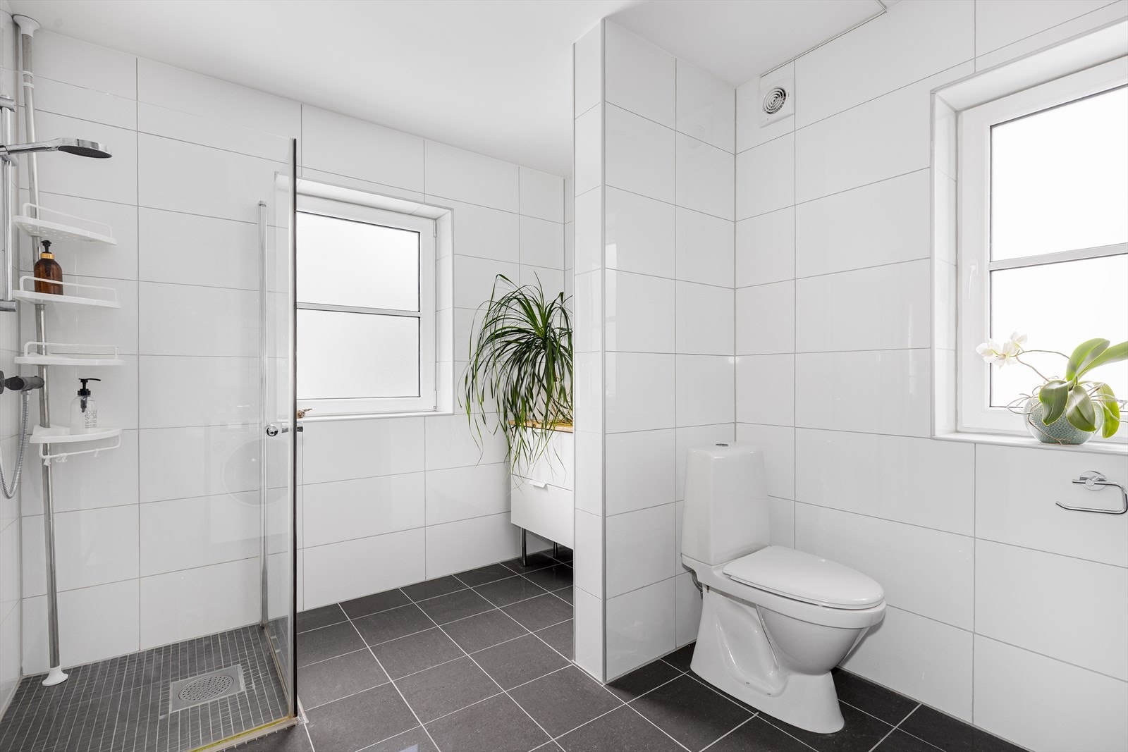 Et praktisk og moderne bad med flislagte overflater og gulvvarme som sørger for god komfort. Galleribilde