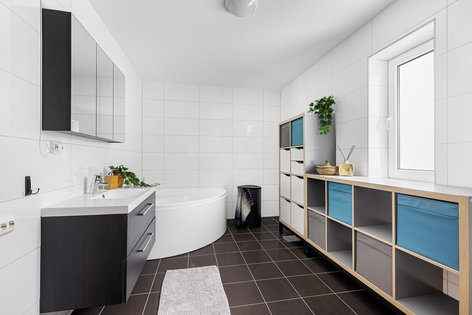 Stort og innbydende flislagt bad med behagelig gulvvarme. Her får du en ekstra følelse av komfort og velvære, med badekar som gir perfekte muligheter for avslapning Galleribilde