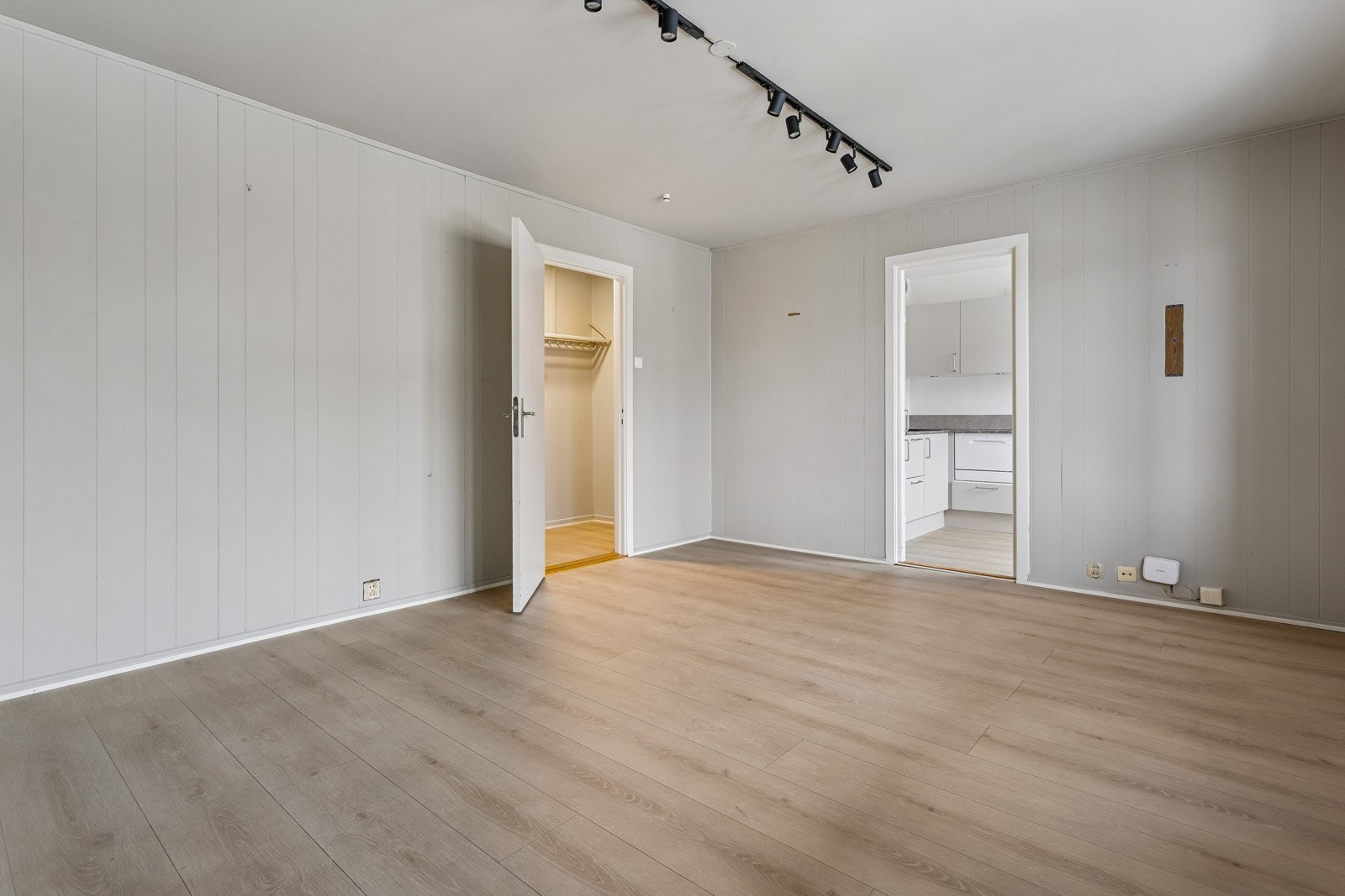 Stue med laminatgulv og lyse vegger. Galleribilde