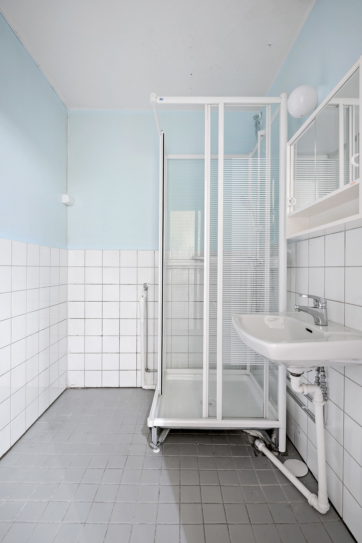 Badet har fliser på gulv, brystningsfliser og malt strie på vegger, samt malte overflater i himling. Galleribilde