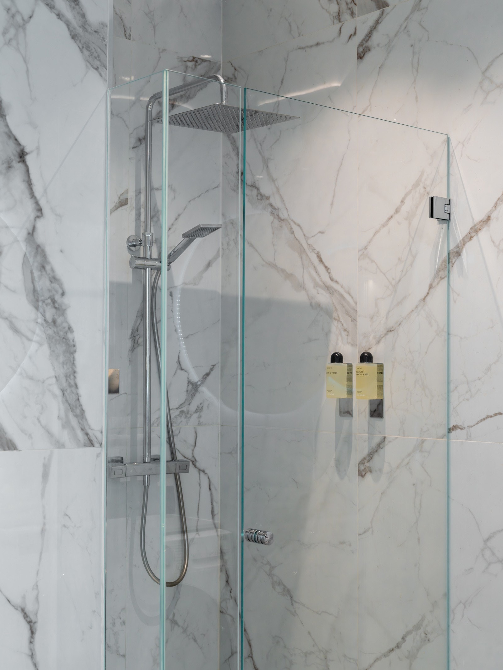 Badet har flislagte overflater med store marmorfliser, varme i gulvet og downlights i taket. Det er også opplegg for vaskemaskin. Galleribilde