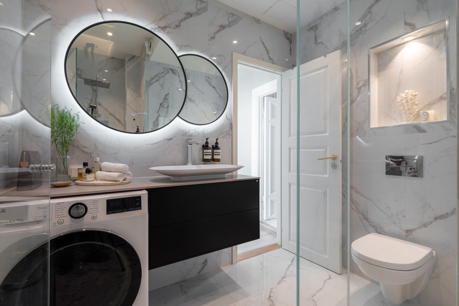 Badet er innredet med vegghengt servantinnredning med benkeplate i stein, speil med integrert belysning, dusjnisje utstyrt med både regndusj og hånddusj, samt vegghengt toalett. Galleribilde