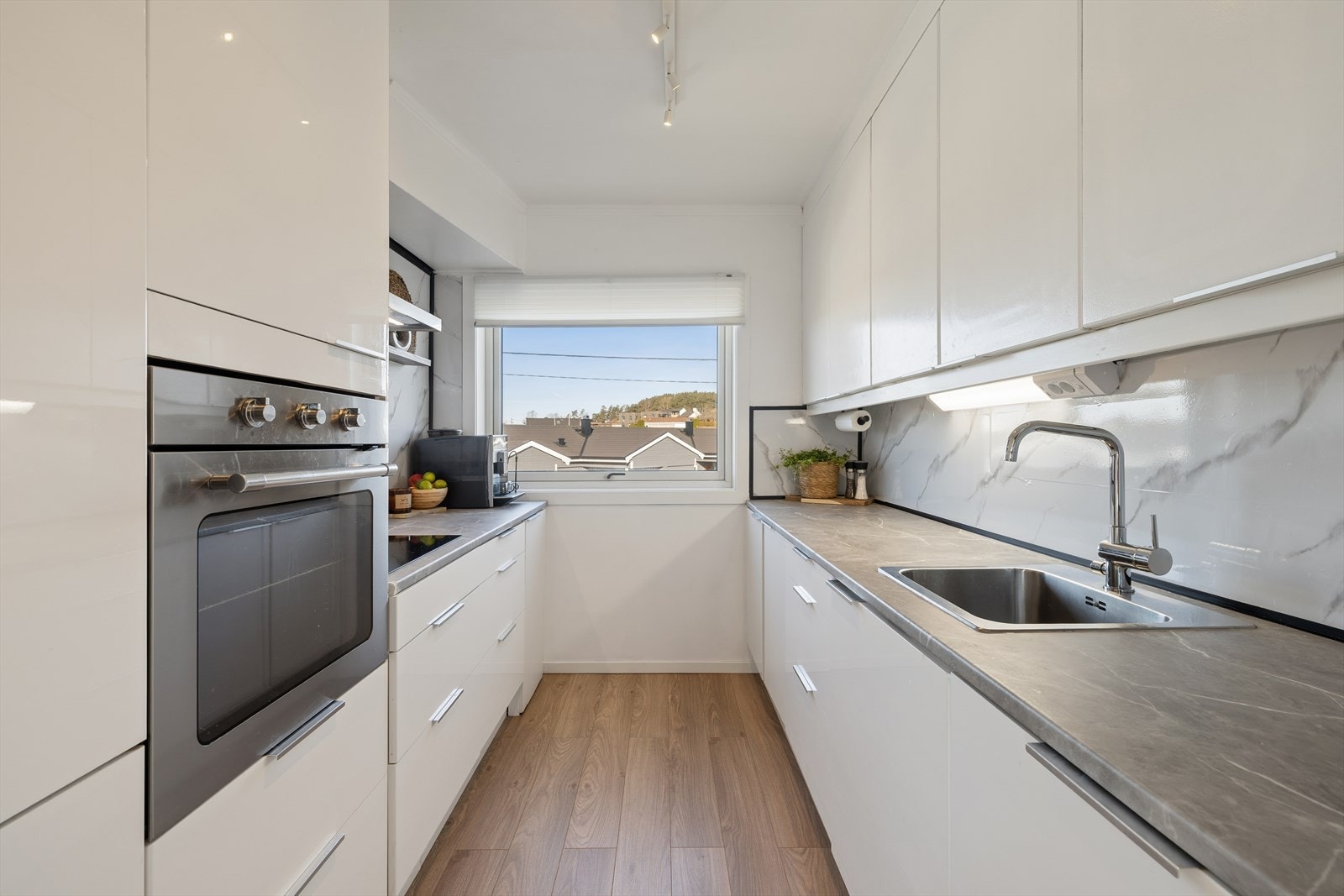 Nyere kjøkkeninnredning med hvite glatte fronter. Galleribilde